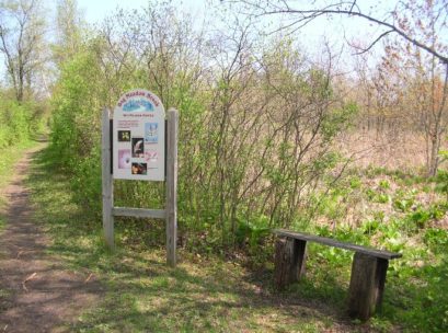 [Photo:  Signage along the trail highlights some of the flora and fauna.]